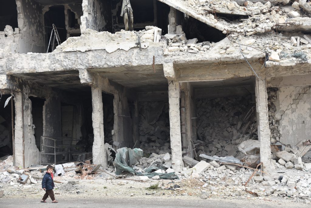 a child is walking through a destroyed building